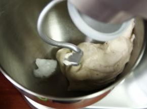 厨师机先1档混合到无干粉，再转2-3档打到面团能拉出厚膜，再加入软化好的椰油，如果椰油是液体状态，要和冰水一起在步骤2就要放入。先1档让椰油和面团融合，再转2-3档打面，打成光滑面团