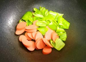 另起油锅，加青椒火腿炒熟。