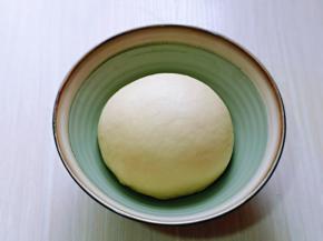 取出揉好的面团，再次揉圆，放入器具中。