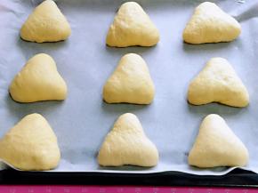 依次做完，放入垫有油纸的烤盘中，并间隔距离，进行二次发酵。(同样一定要注意保持面团的湿度)