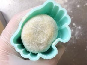 模具里扫一层薄薄的干粉，把面团也滚一层薄薄的干粉，放入