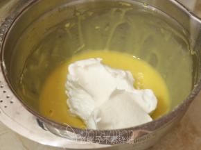 剩下的蛋白霜取1/3加入到蛋黄糊中，用橡皮刮刀翻拌均匀。