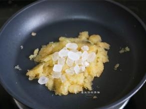 把接出来的果渣放入不粘锅里，加入冰糖，小火慢炒。