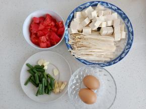 西红柿豆腐分别切块，葱姜蒜切碎，金针菇洗净撕开