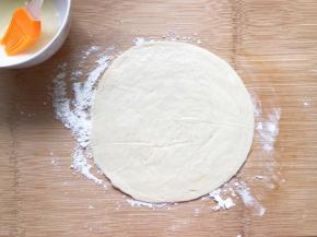 一张手抓饼上刷上蛋白，下面用点面粉防止粘黏