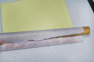 上面抹沙拉酱或者炼奶，我用的时炼奶，非常好吃。在切口另一端，用擀面杖压一下边缘。卷起蛋糕卷