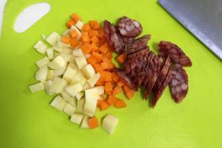 土豆和胡萝卜去皮切丁，腊肠切片。