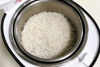 大米淘洗净，接着倒入滤网上。