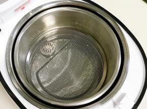 往臻米电饭煲不锈钢内胆中安装甄子和小滤网。
