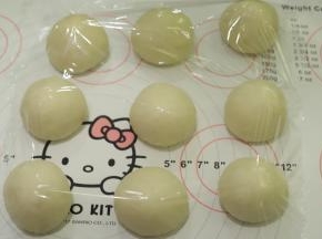 将面团轻压排气后平均分成9份，盖上保鲜膜松弛15分钟。