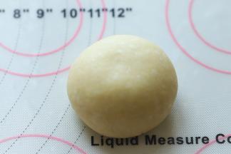 将面团再次搓圆，收口捏紧，朝下。