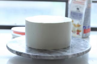 两次同样抹好奶油和水果后，盖上最后一片蛋糕片，整个蛋糕抹上淡奶油，抹刀刮平表面。