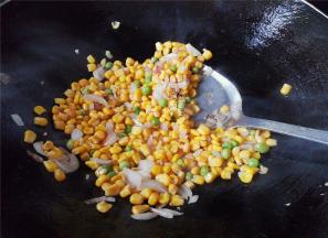 把玉米青豆倒入跟洋葱碎一起翻炒，食材炒得香喷喷。