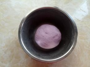 戴上一次性手套，把糯米粉和紫薯糊糊揉成光滑的面团，盖上保鲜膜放20分钟