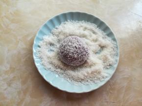 蒸好的紫薯趁热有些水汽，放到盛有椰蓉的盘子里滚上几圈，沾满椰蓉，放到小的纸托上。