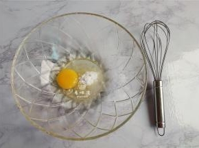 首先把鸡蛋磕入料理盆中，倒入食用油和糖粉，用打蛋器搅拌均匀。