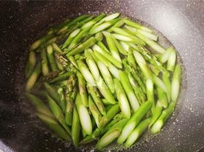 首先把芦笋洗净，切除老根部，斜刀切断，烧一锅沸水，把芦笋段倒入焯水备用。