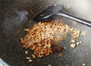 接着倒入料酒跟猪肉末翻炒，去腥，倒入盐，和生抽调味。