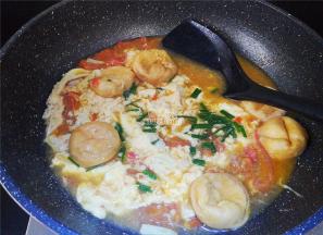 等鸡蛋凝结成块，再用锅铲翻动，撒入少许葱花。