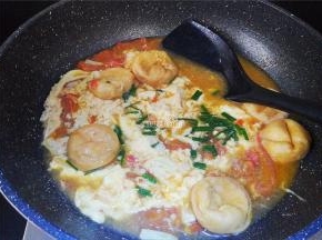 等鸡蛋凝结成块，再用锅铲翻动，撒入少许葱花。