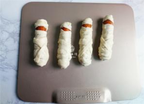 备一个烤盘，把裹好的香肠木乃伊摆放上去.