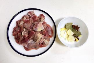 牛腩用清水浸泡半小时去去血水，然后洗净沥干用刀切块，姜、蒜、葱叶切好。