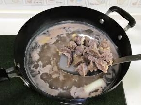 锅中倒入适量的清水，放入切好的牛腩，倒入1勺料酒，放1段大葱和2片姜，开火煮沸后捞出，用清水冲洗干净。