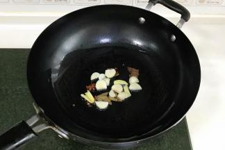 锅中倒入食用油，下姜、蒜和八角、香叶、花椒爆香。