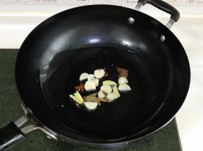 锅中倒入食用油，下姜、蒜和八角、香叶、花椒爆香。
