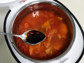 待电饭煲煲汤结束，把煸炒好的番茄、土豆和胡萝卜连带汤汁一起倒入锅中，加入1勺生抽。