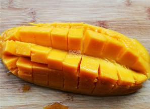 首先把芒果切半，取下果肉装入食品袋，冰箱里冷冻备用。