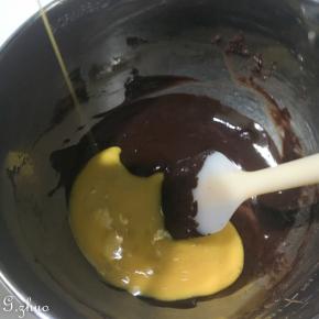 融化后的巧克力分两次加入蛋液，搅匀后再加入第二次，