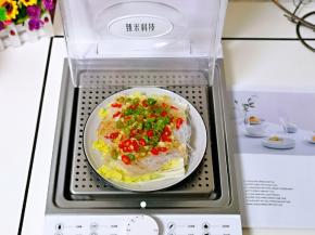 将装有菜品的盘子放入蒸锅底层的蒸屉上。