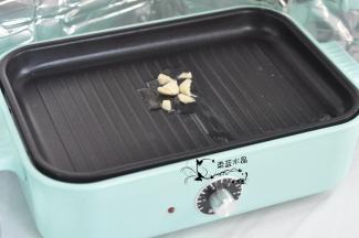 锅里倒入油，放入蒜炸香。