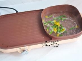 将多功能一体锅的火锅按钮打开，锅里水烧开后，放入黄瓜花煮20秒。