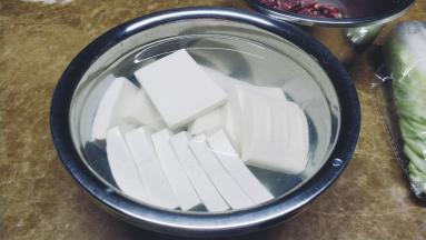 豆腐先切片用盐水浸泡一会
