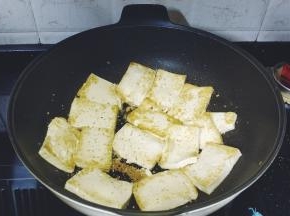 锅里热油放入少许蒜盐将豆腐煎至两边微黄，盛出备用
