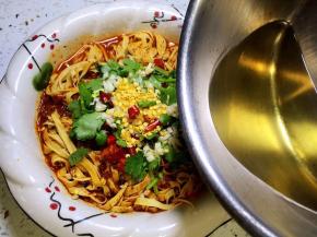 淋在干红辣椒、香菜段、蒜末上