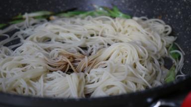 小葱炝锅，捞入面条 加味达美酱油翻炒均匀