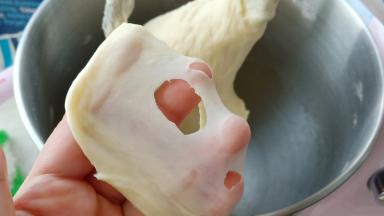 揉10分钟左右，拉出的膜破洞边缘呈锯齿状。这时放入黄油继续揉。