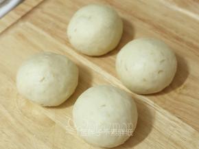 发酵好的面团按压排气，之后平均分成4个面团，将它们都滚圆之后盖上保鲜膜松弛15分钟。