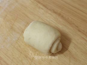 接着把松弛好的面团再次擀开，继续由上往下卷起来。