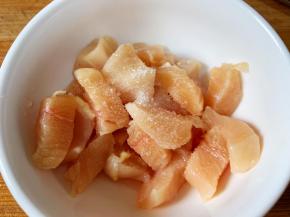 煮粥的时候，我们来准备配菜，鸡胸肉切1厘米见方的小块，加入料酒、食盐，拌匀腌制一会