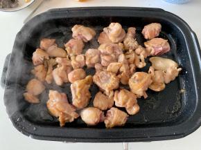 锅中留底油，保持中火的状态，倒入腌制好的鸡块，不要着急翻动，等到一面煎至金黄变硬后再用筷子逐个翻面，使两面都煎至金黄。