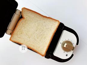 打开预热好的三明治机，放上三明治,盖紧盖子，加热三分钟