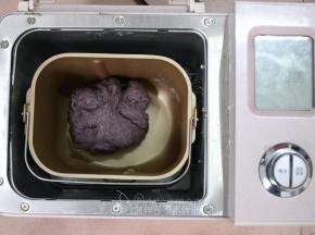 除黄油外，将面团中的其它原材料放入面包桶中，启动一个揉面程序，揉至能拉出厚膜。