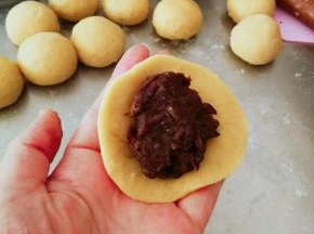 取一份檊成圆形面皮 放上红豆馅