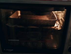 二次发酵后 在面饼上覆盖一层油纸 再放入一个烤盘 压住面饼胚  我的烤箱165度  预热5分钟  上下火烤了20分钟  最下面放了半碗开水