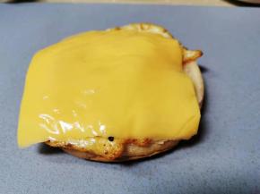 在汉堡胚放上鸡蛋，铺上芝士片