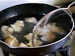 锅中水沸，搅动水，下饺子，继续沿锅边搅动，是饺子在水中转动，避免沉底，盖盖。